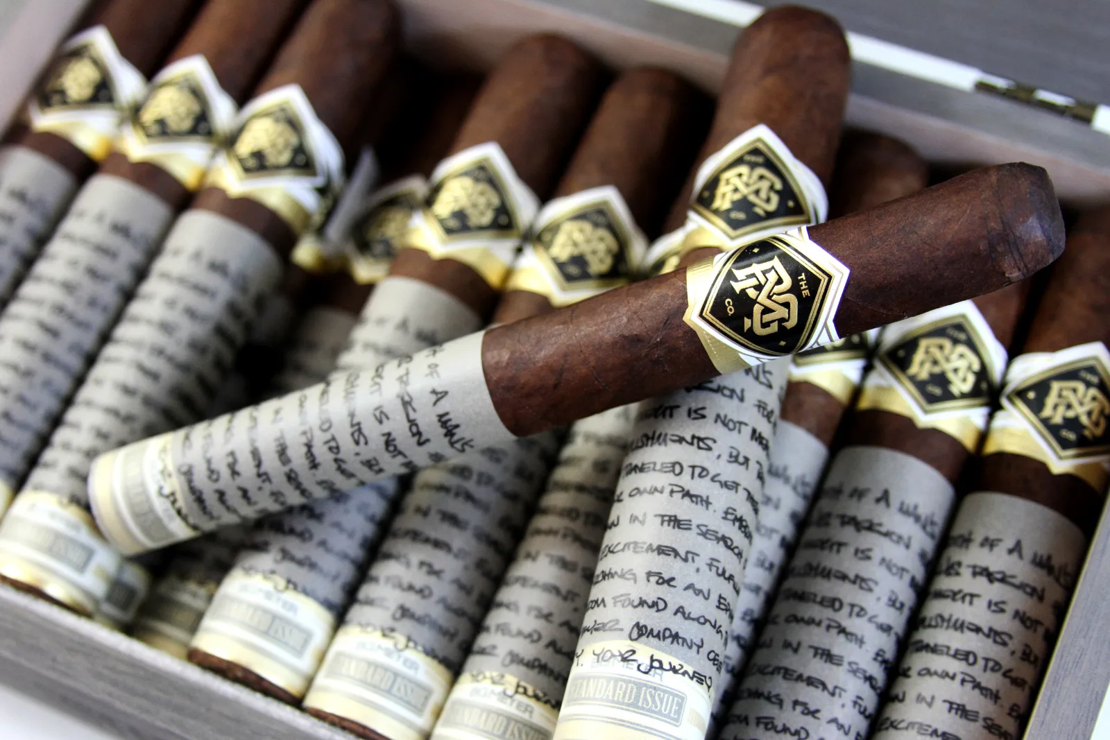Banded cigars lying in an open wooden box, close up
